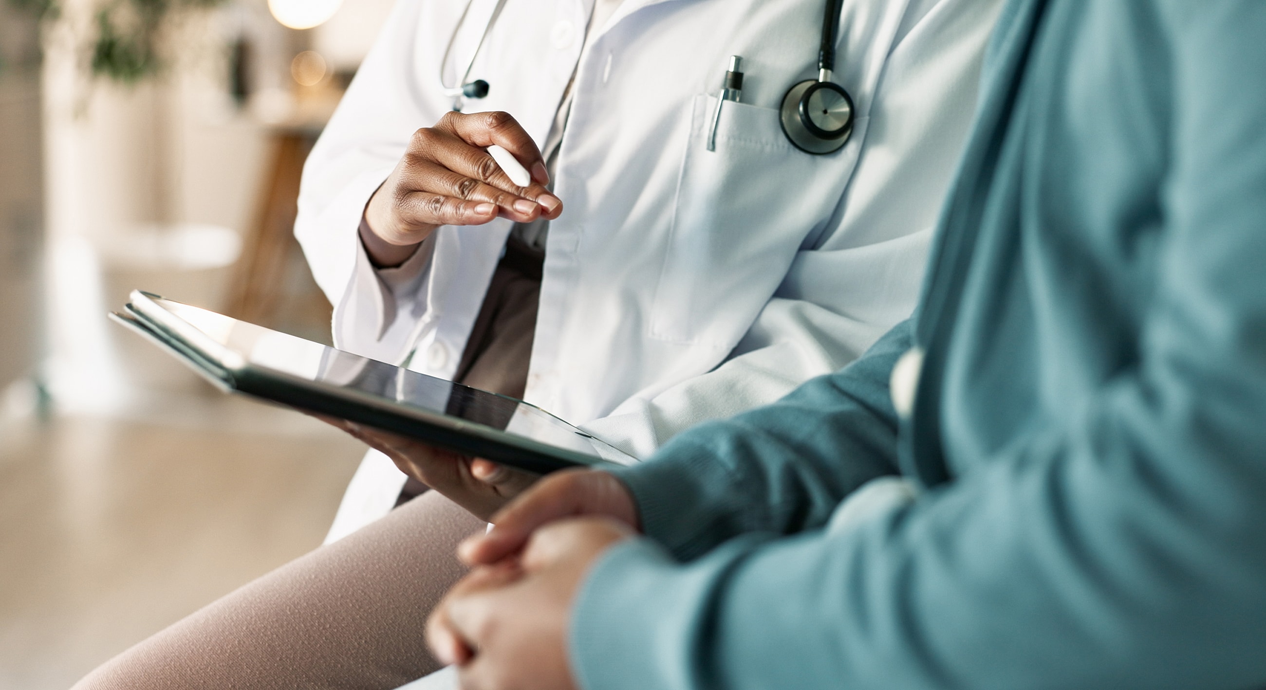 Doctor consulting with patient using a tablet.