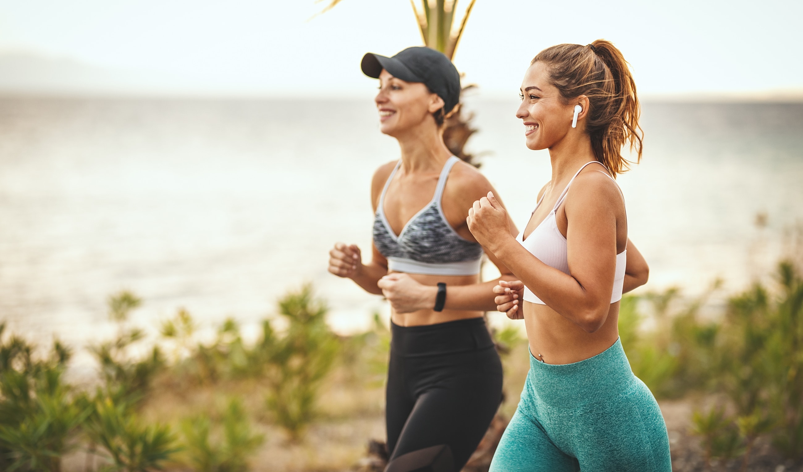 Women jogging by the beach, enjoying fitness together.